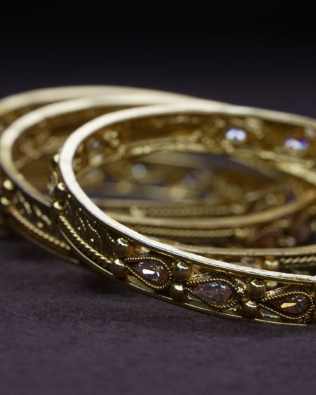 A pair of engraved antique-gold bangles with stone detail