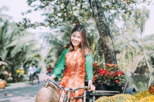 Woman in Green Long Sleeve Shirt Riding Bicycle