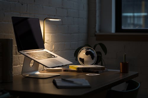 Macbook Pro on Stand Beside Desk Globe