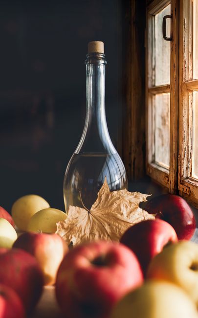 Bottle of apple cider vinegar with fresh apples