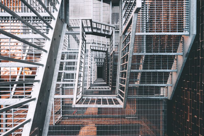 Overhead view of an industrial steel staircase with staggered flights spiraling downward