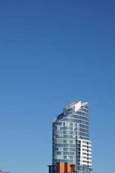 Modern skyscraper in Portsmouth against a vivid blue sky, showcasing architectural design.