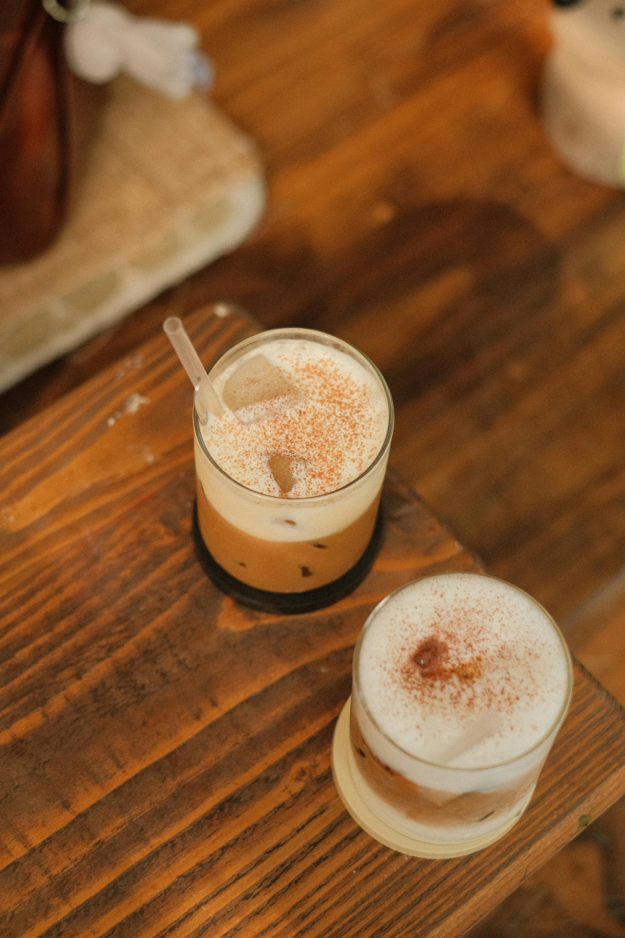 Two cinnamon-dusted iced coffees on a café table, closer to the mainstream coffee-shop version of horchata than a formal dessert