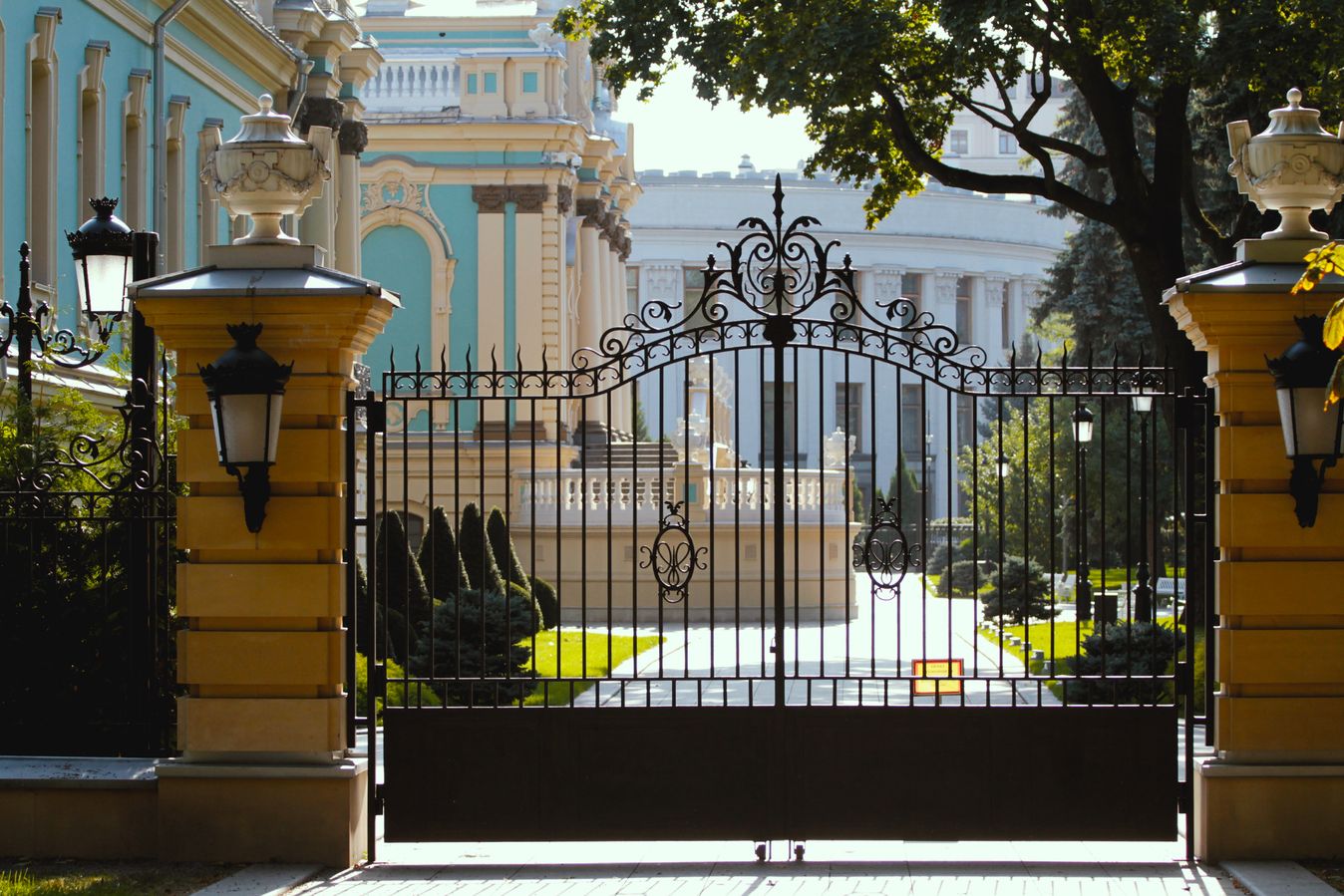 Estate perimeter with custom iron gate and stone pillars