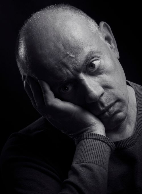 Free Dramatic black and white portrait of a pensive adult man with hand on face. Stock Photo
