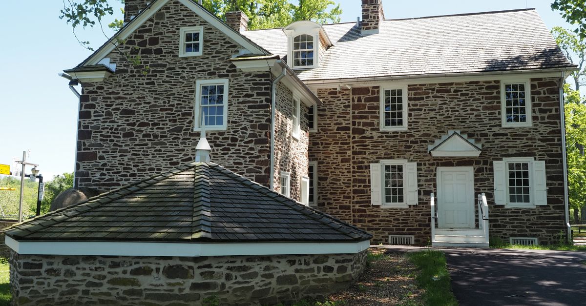 Charming stone building in Washington Crossing, PA surrounded by lush greenery on a sunny day.
