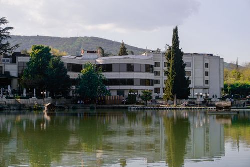 Free A picturesque building by a tranquil lake in Stara Zagora, Bulgaria, surrounded by greenery. Stock Photo