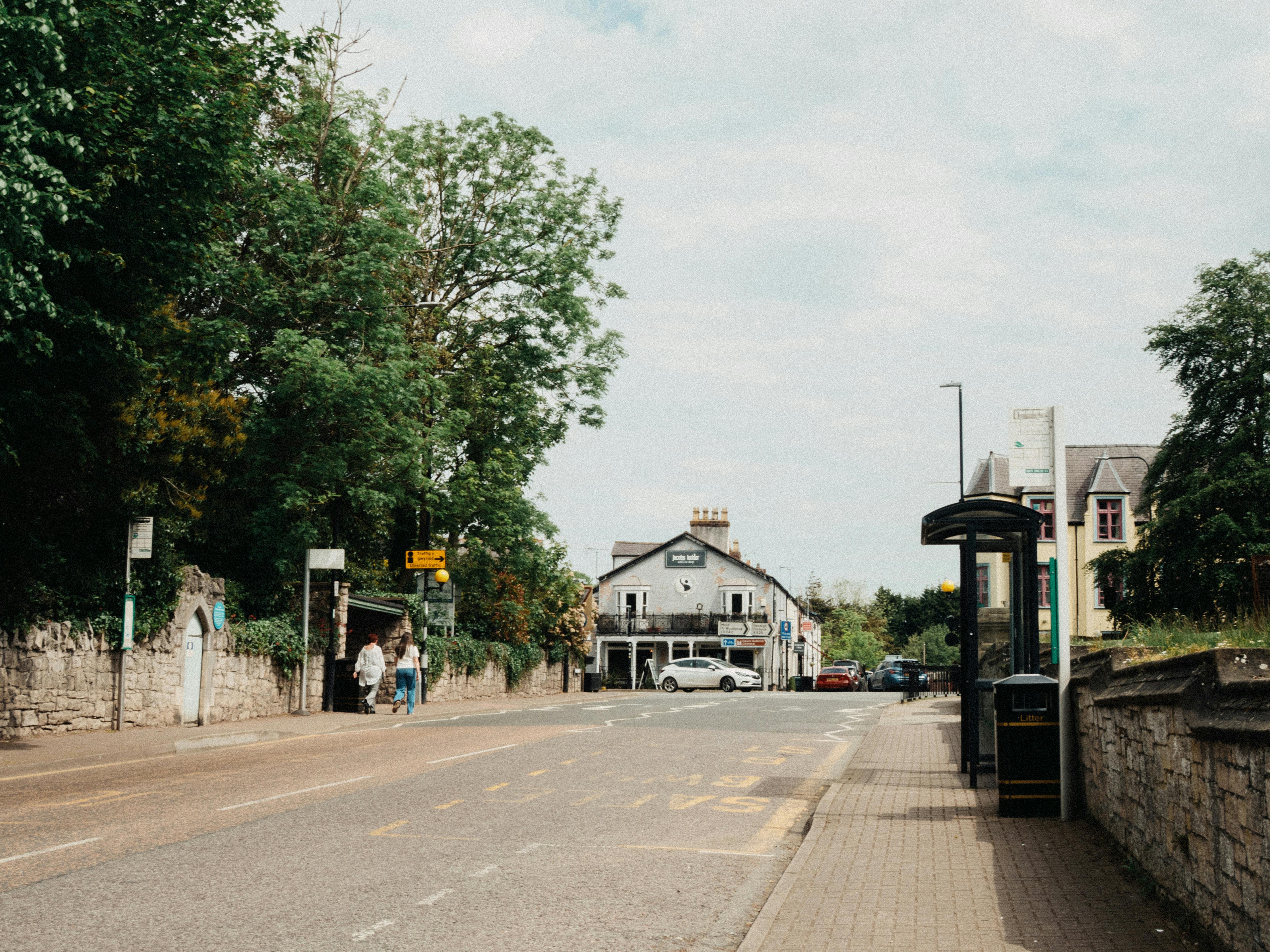 Charming street view in Saint Asaph, Wales with bus stop and quaint buildings.