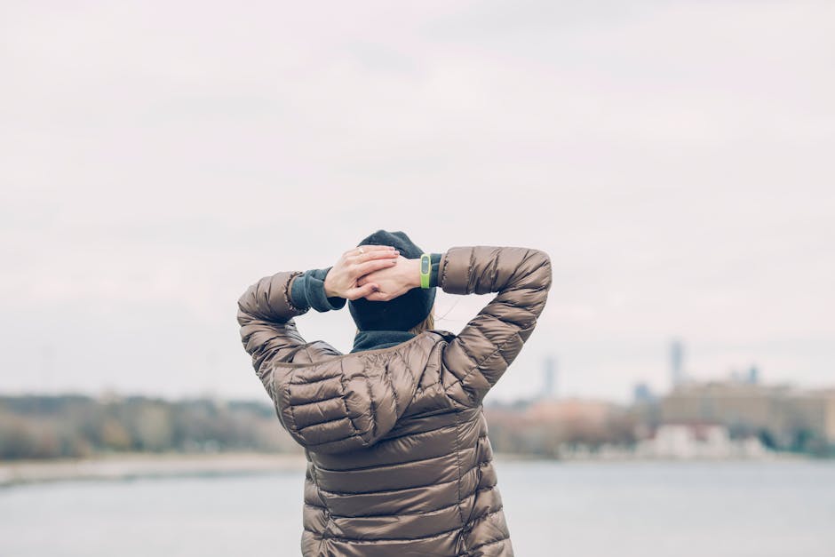 Person Holding Head Facing Body of Water