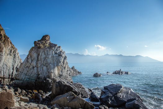 日出时分，岩石海岸景色令人惊叹，海水清澈，远处山丘连绵
