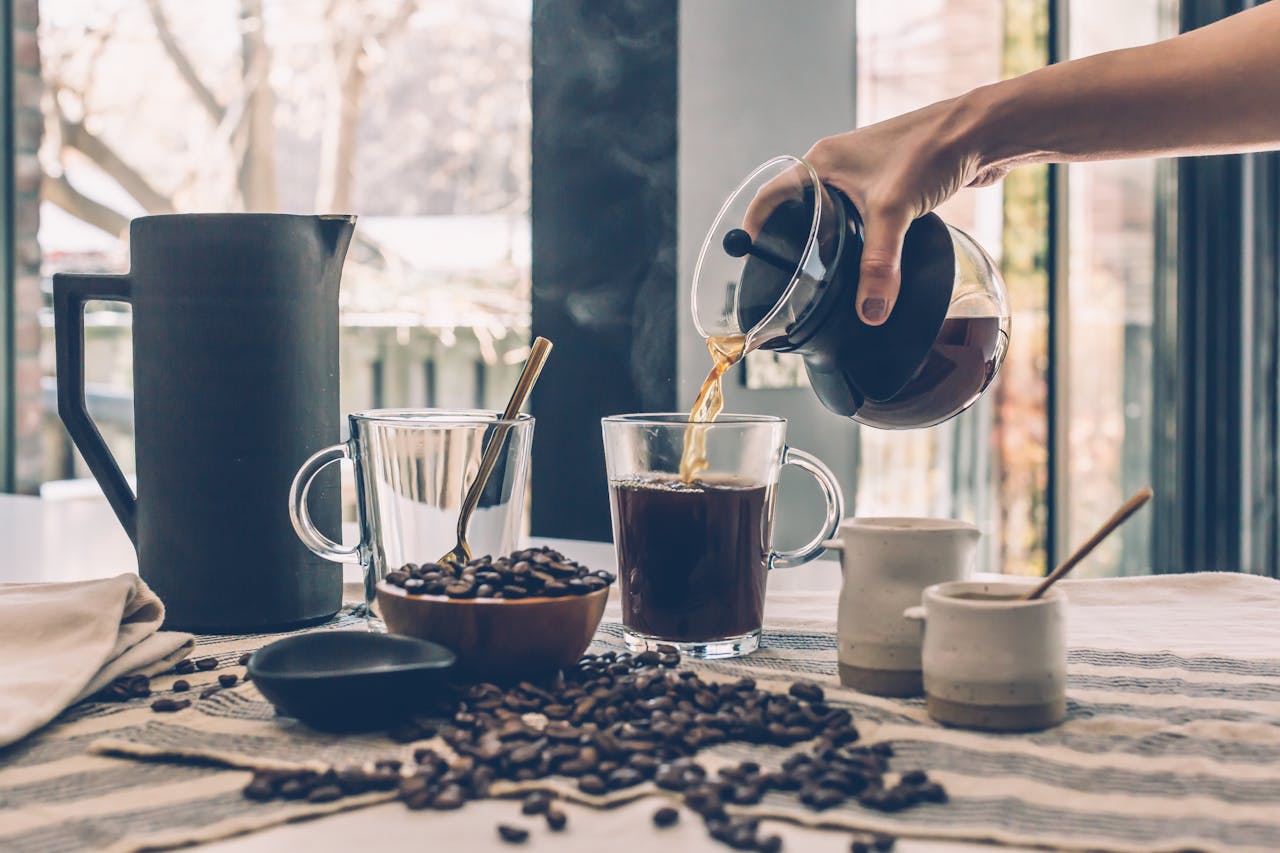 Hands holding a warm mug by a window