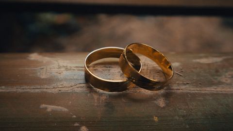 Beautiful gold wedding rings placed elegantly on a rustic wooden surface.