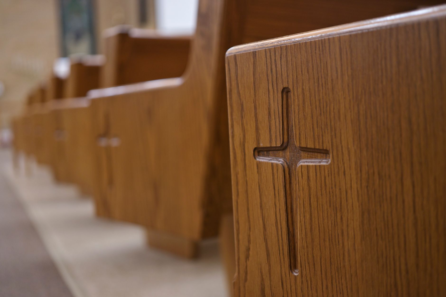 Detailed view of wooden church pews with cross carvings in a Berlin, Wisconsin church.