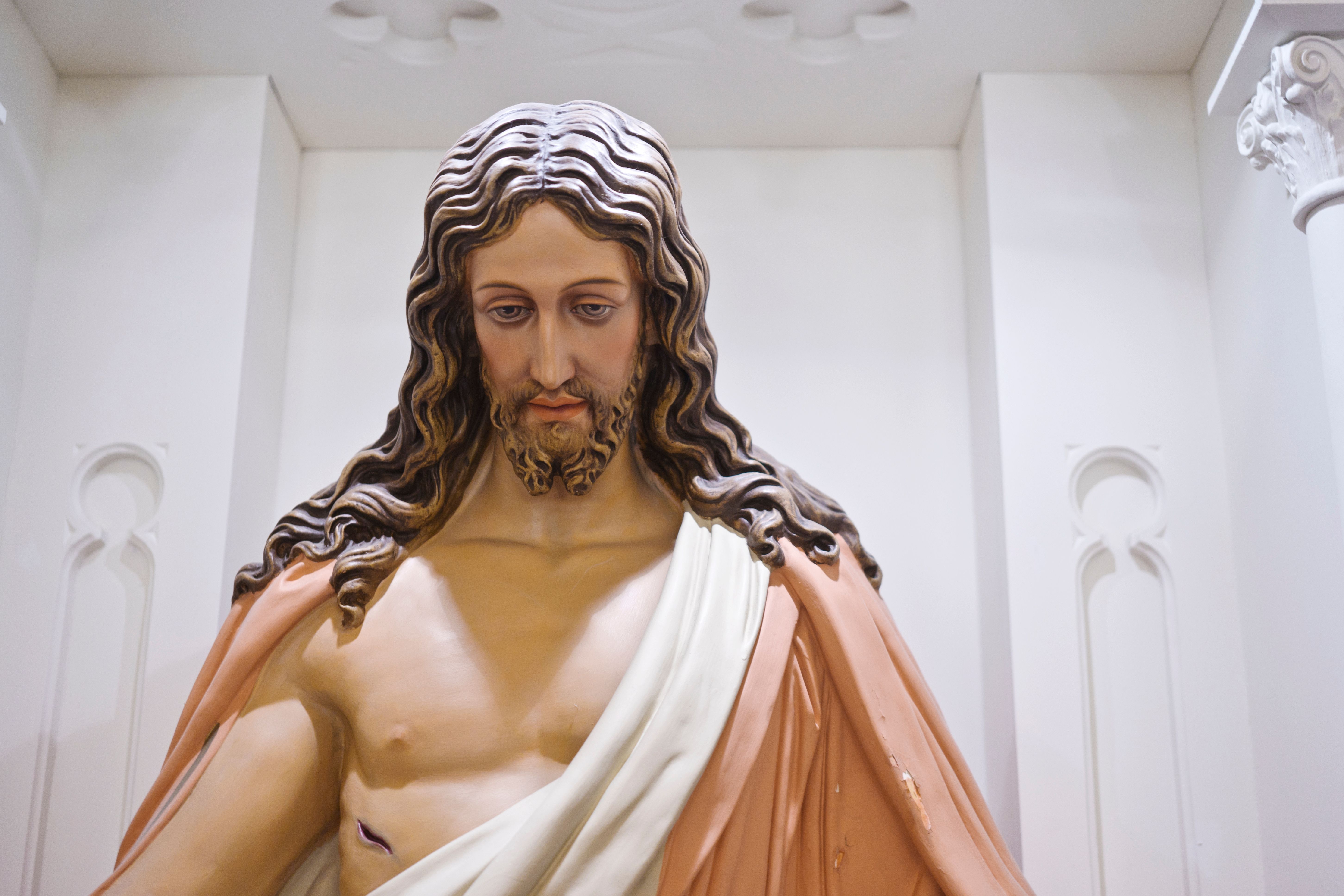 Detailed wooden statue of Jesus inside a church, symbolizing peace and spirituality.