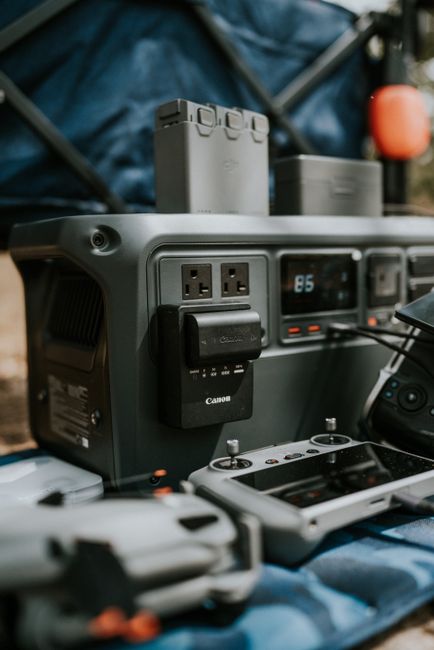 Outdoor setup featuring a portable power station with various drone and camera accessories on a blue surface.