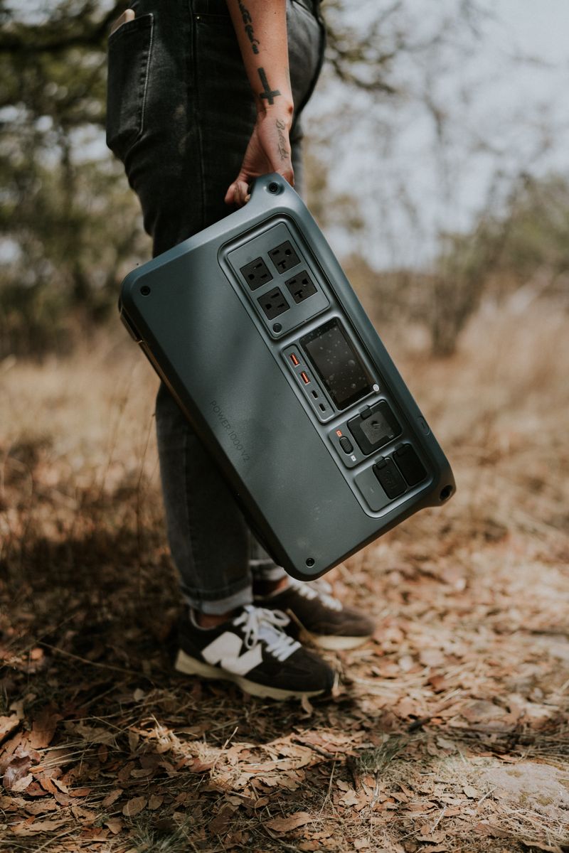 Person carrying a portable power station through the bush