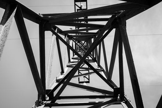 A striking black and white perspective of a metal tower from below, showcasing industrial design.