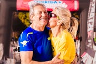 阳光明媚的日子里，一对快乐的老年夫妇在户外拥抱欢笑