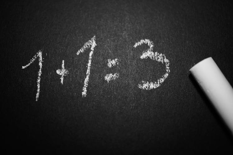 1 + 1 = 3 Text On Black Chalkboard