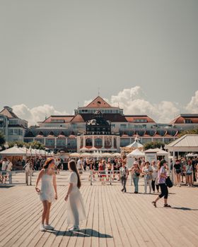 Crowds enjoy a sunny day at Sopot Pier with historical architecture and vibrant atmosphere.