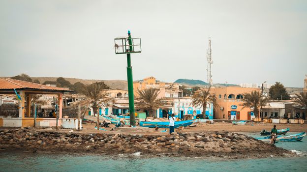 Vue pittoresque du front de mer de Tadjoura avec ses bateaux et ses bâtiments, illustrant la vie côtière à Djibouti.