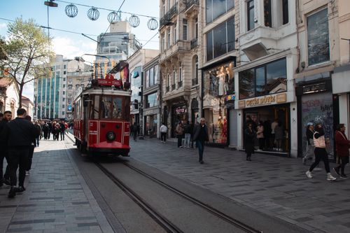 Free Historic red tram on bustling Istiklal Street, Istanbul, with pedestrians and shops. Stock Photo