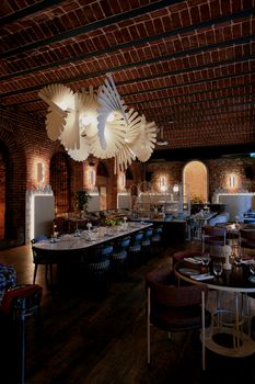 Stylish restaurant interior featuring unique pendant lights, exposed brick walls, and elegant dining setup.