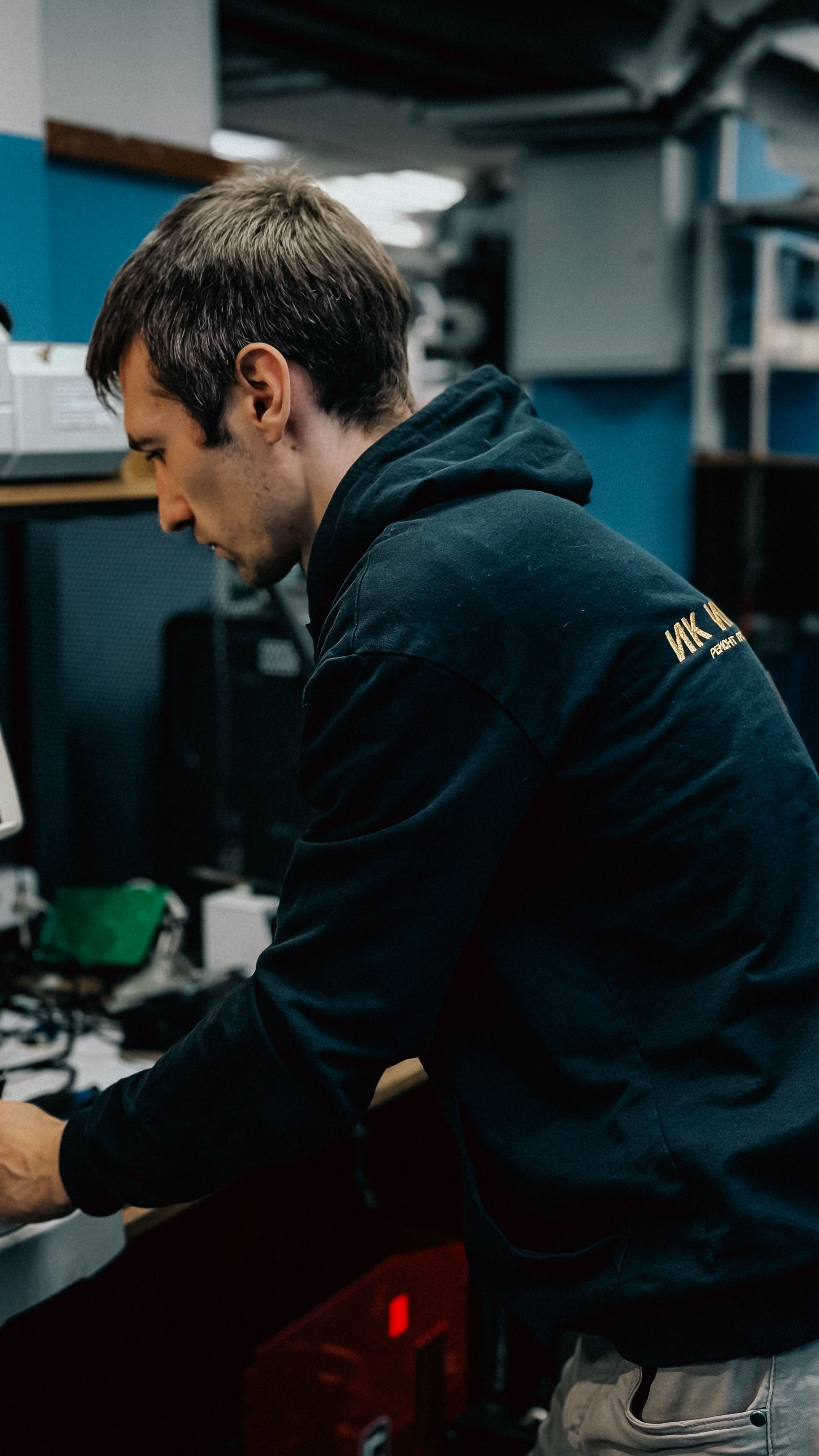 Zadarmo Zameraný technik opravujúci elektroniku v modernom dielenskom prostredí. Fotka z fotobanky