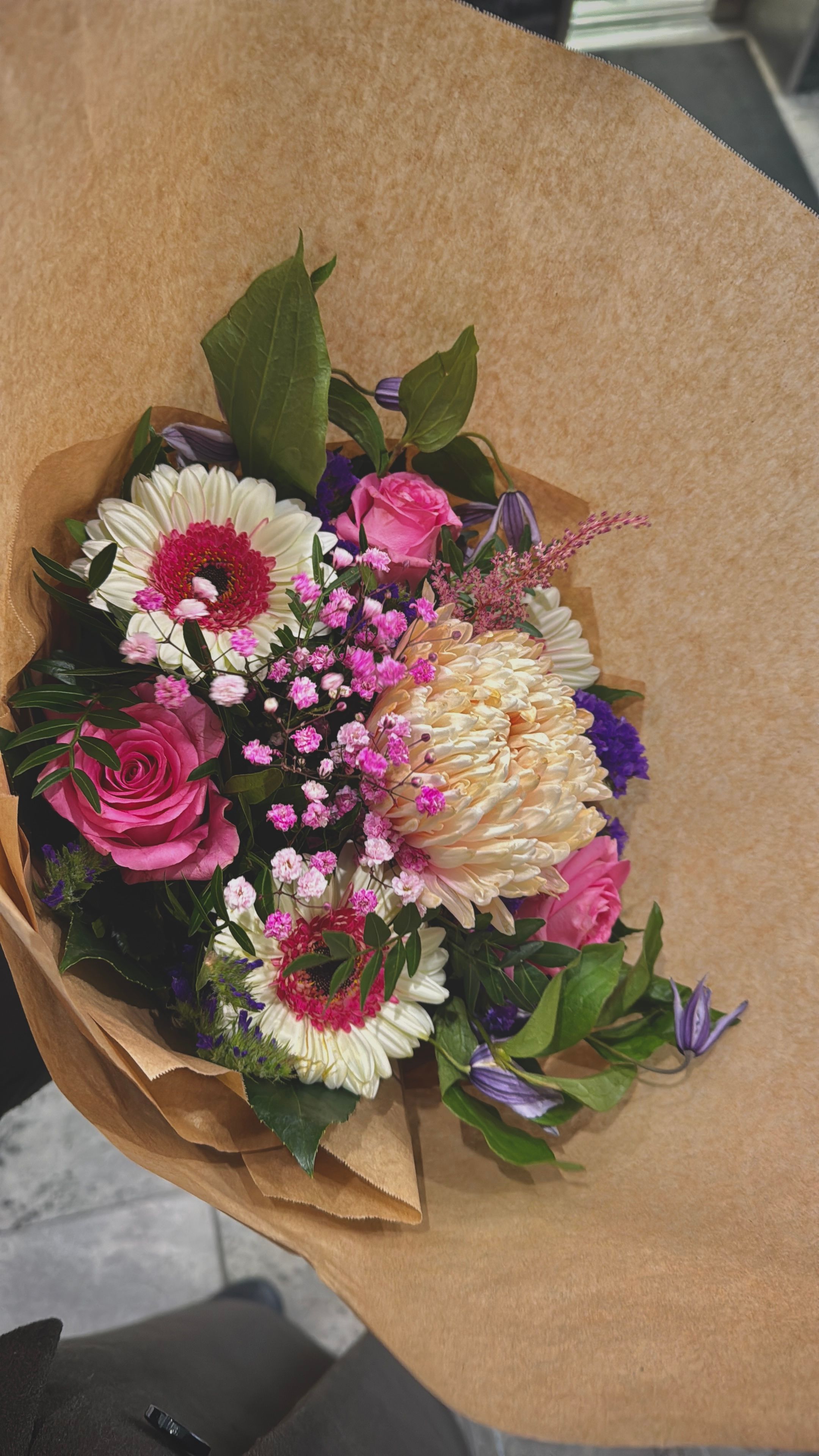 A small hand-tied bouquet in kraft paper.