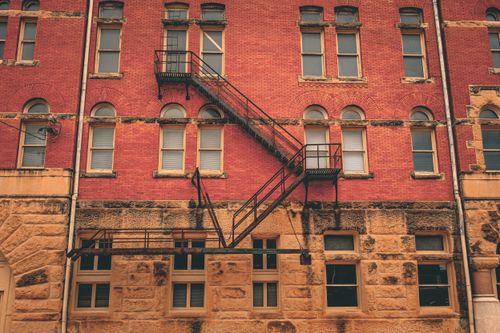 Free Vintage red brick building exterior with fire escape in Waxahachie, TX. Stock Photo