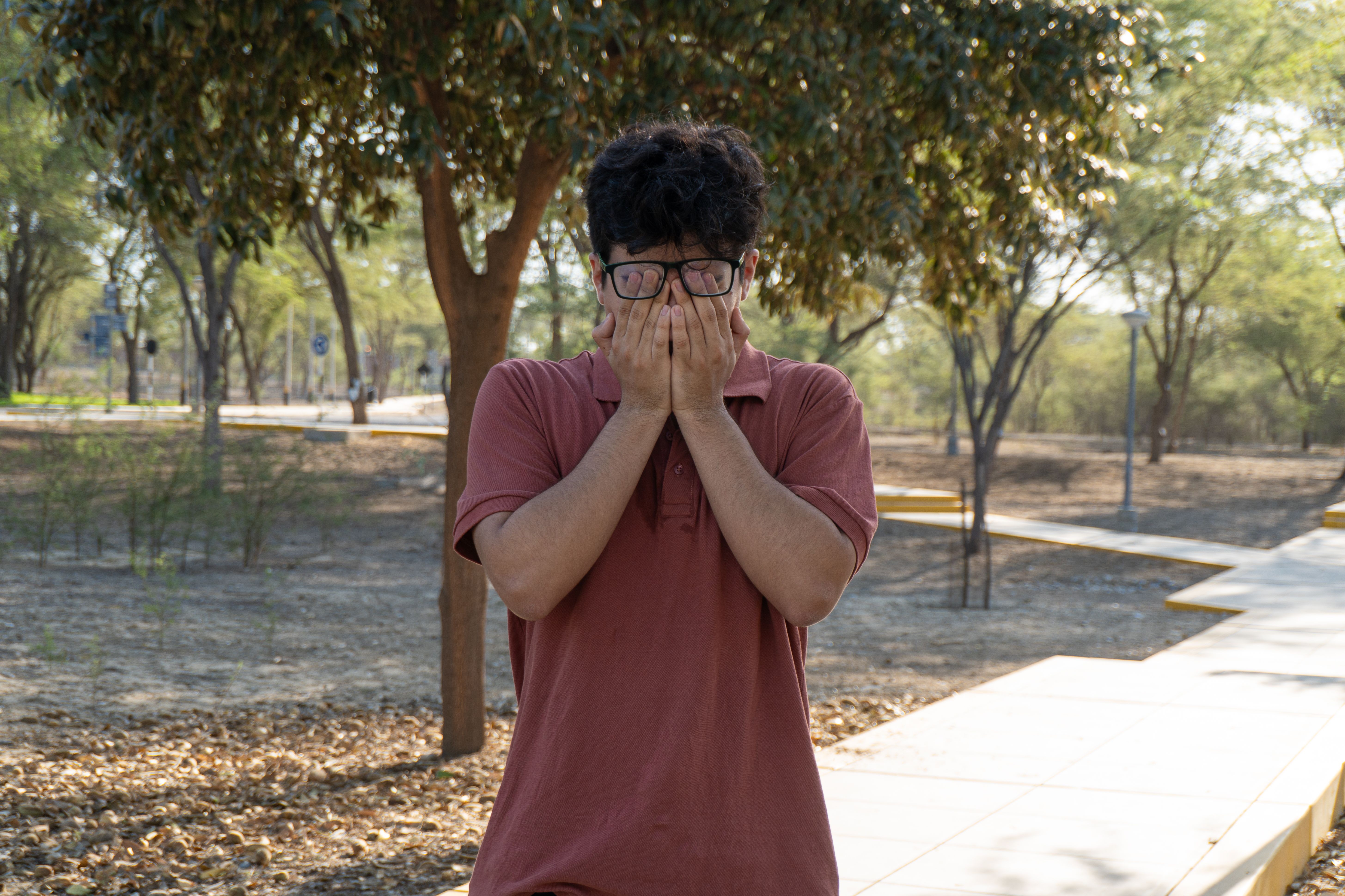 Joven Se Cubre El Rostro En Un Parque Al Aire Libre. · Foto de stock ...