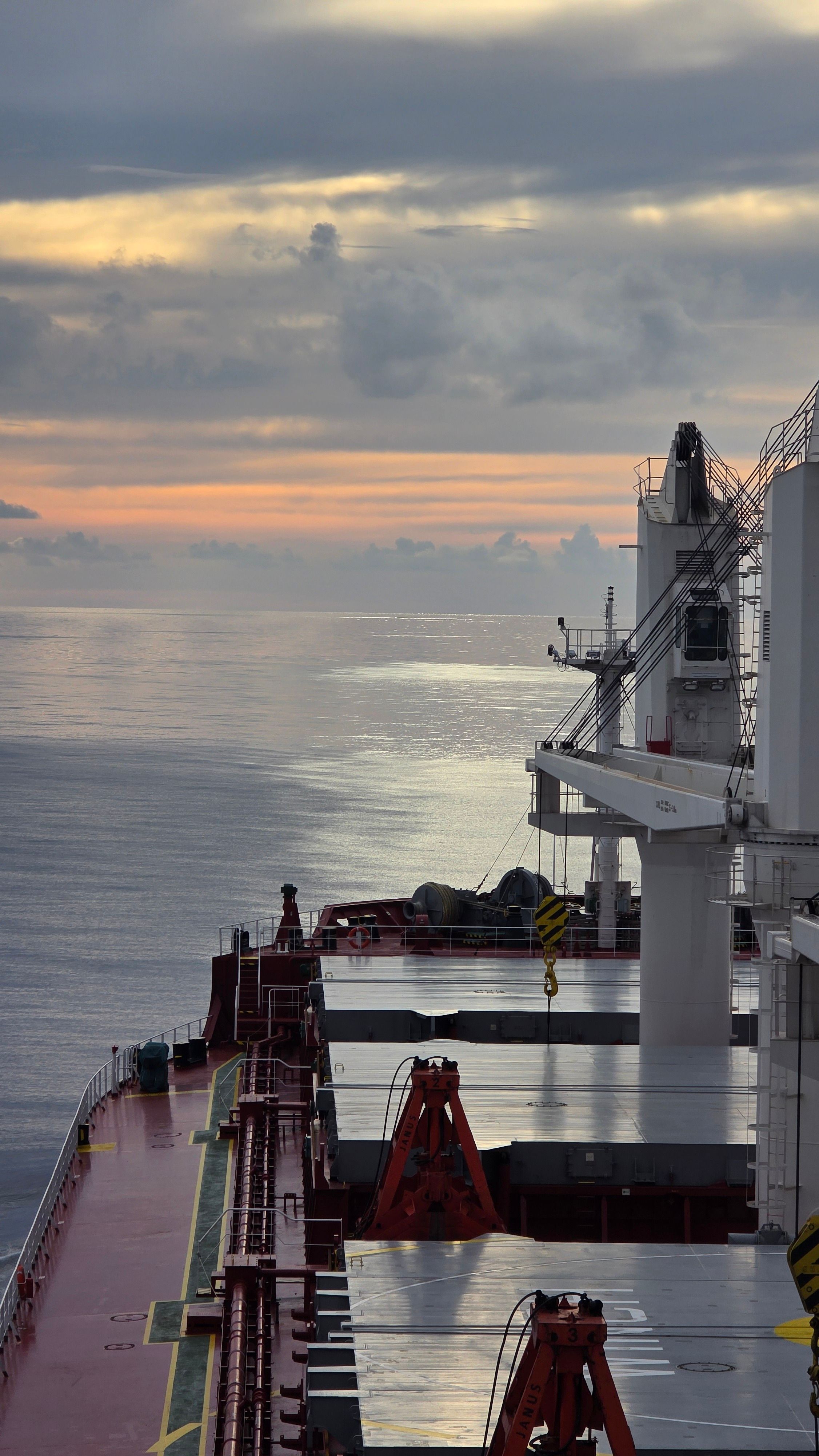 A serene view of a container ship against a sunset in Güney Afrika waters.