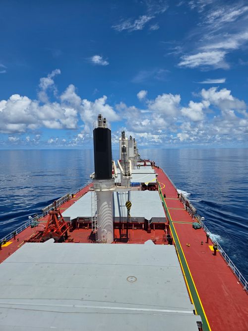 Free A cargo ship sails through the serene ocean with a clear blue sky overhead, captured in striking detail. Stock Photo