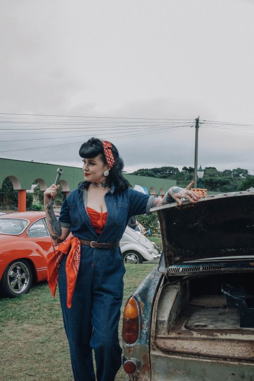 Free Vintage-themed photo of a woman mechanic working on a classic car engine outdoors. Stock Photo