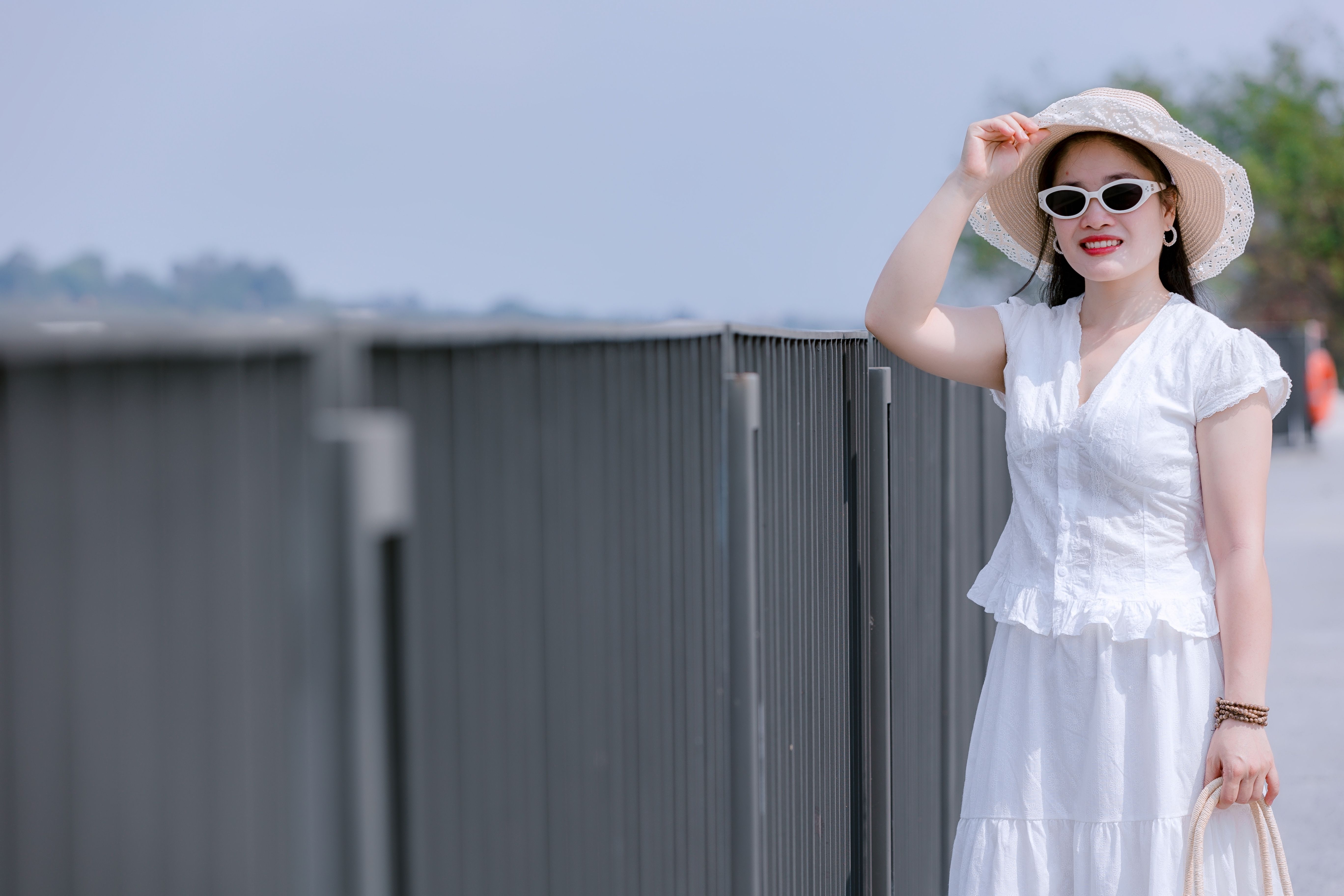 A stylish summer outfit featuring lightweight fabrics and accessories in a sunny park