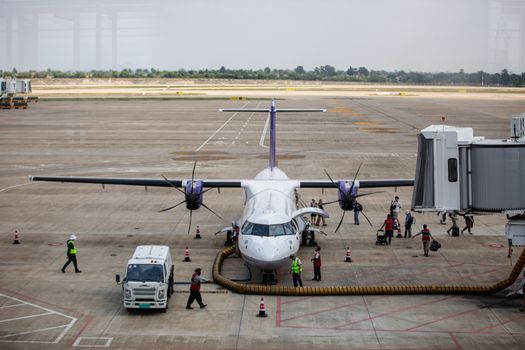 Passengers board an aircraft at a Cambodian airport, showcasing aviation and travel.