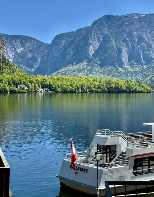 Free Serene mountain and lake scene in Hallstatt, Austria with a boat in the foreground. Stock Photo