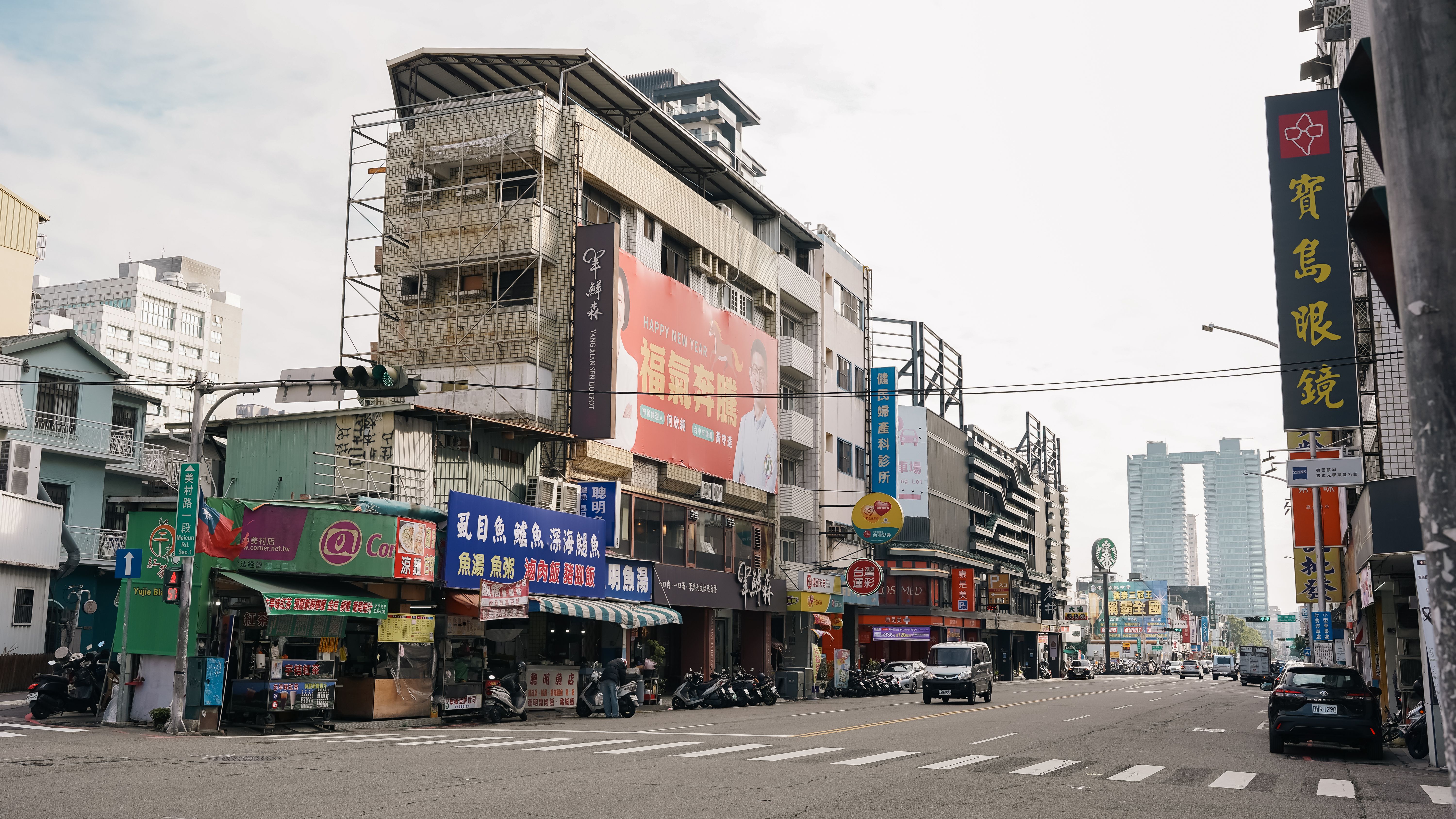 Dynamic urban street view in Taichung City, Taiwan featuring colorful signage and bustling activity.