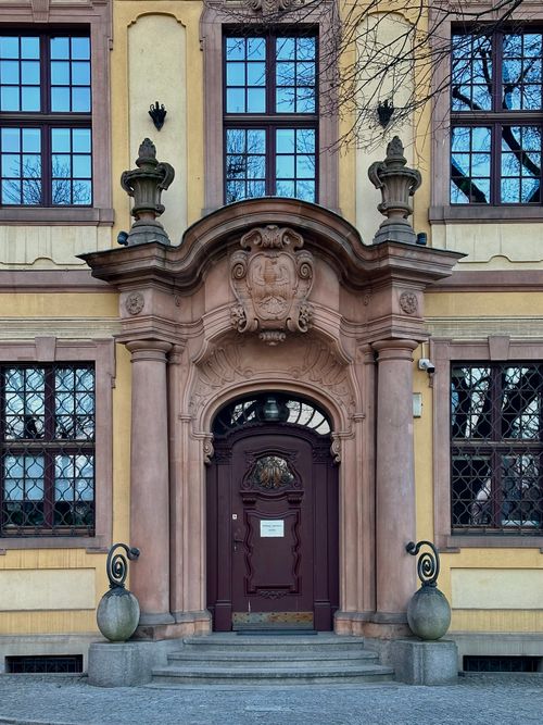 Free Elegant classical building entrance featuring Baroque architecture with intricate stonework and decorative elements. Stock Photo