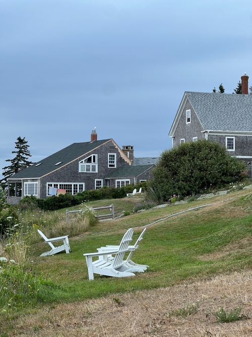 Free Rustic coastal cottages with Adirondack chairs on a grassy hill in Maine. Stock Photo