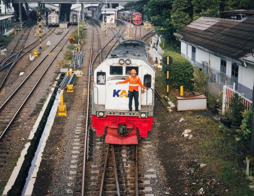 Free A train conductor stands on the front of a train at Bandung Railway Station, Indonesia. Stock Photo