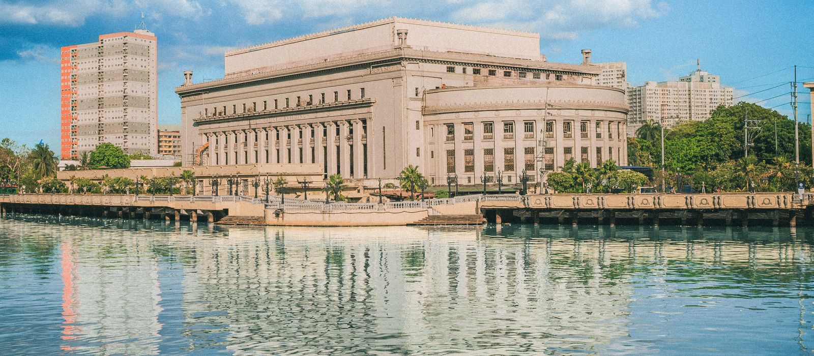 The iconic Manila Post Office building reflecting on the Pasig River under a bright blue sky. — flights from Bandar Seri Begawan to Manila