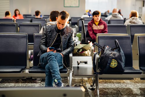 Man in Black Leather Jacket Sitting on Chair