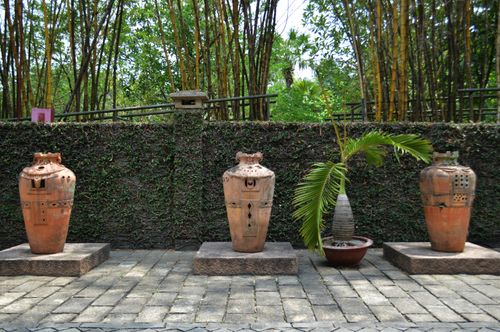 Free Elegant terracotta pots aligned on stone bases in a tranquil garden with lush greenery. Stock Photo