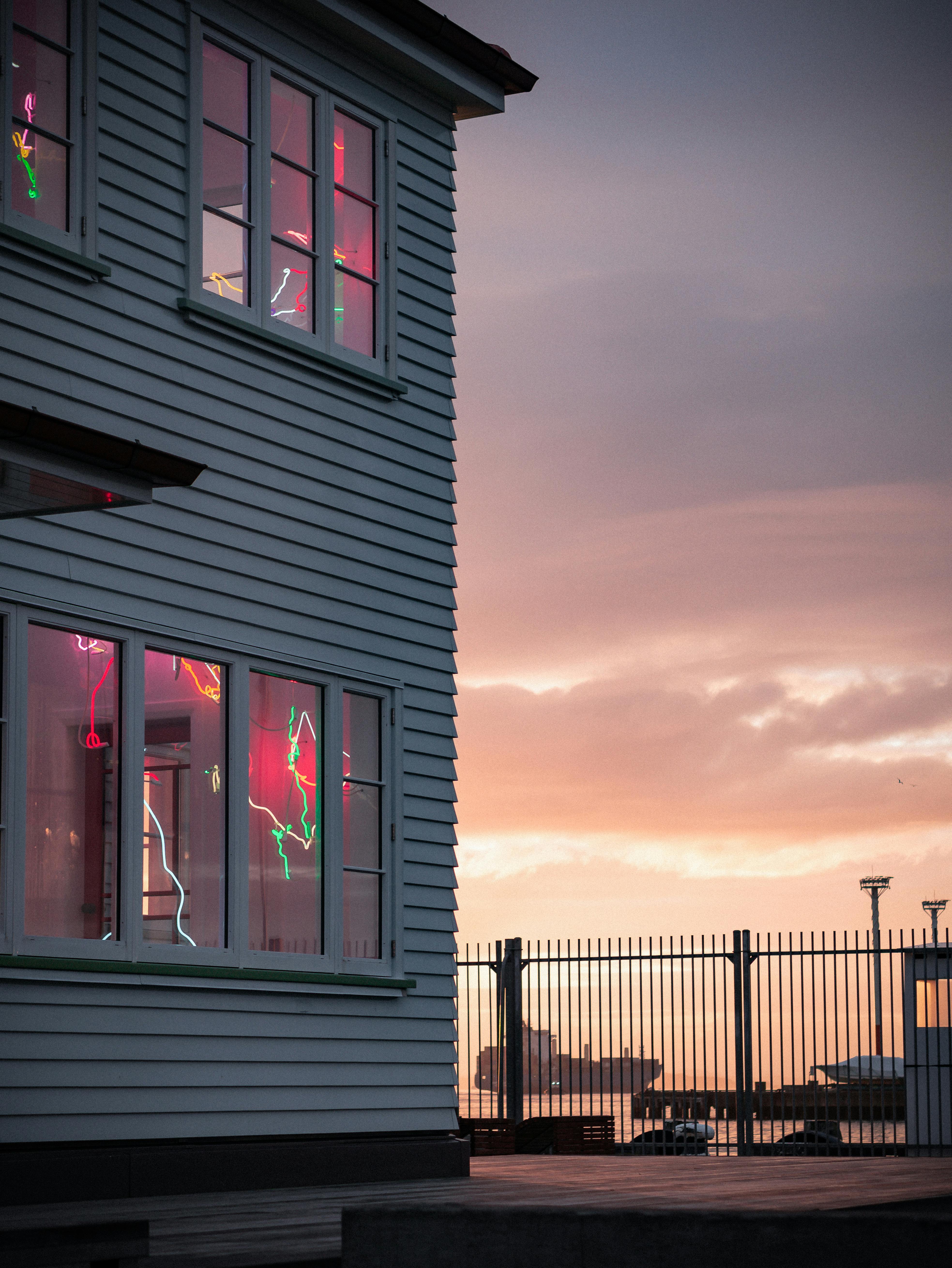 日落时分，奥克兰港附近霓虹灯下的木制房屋