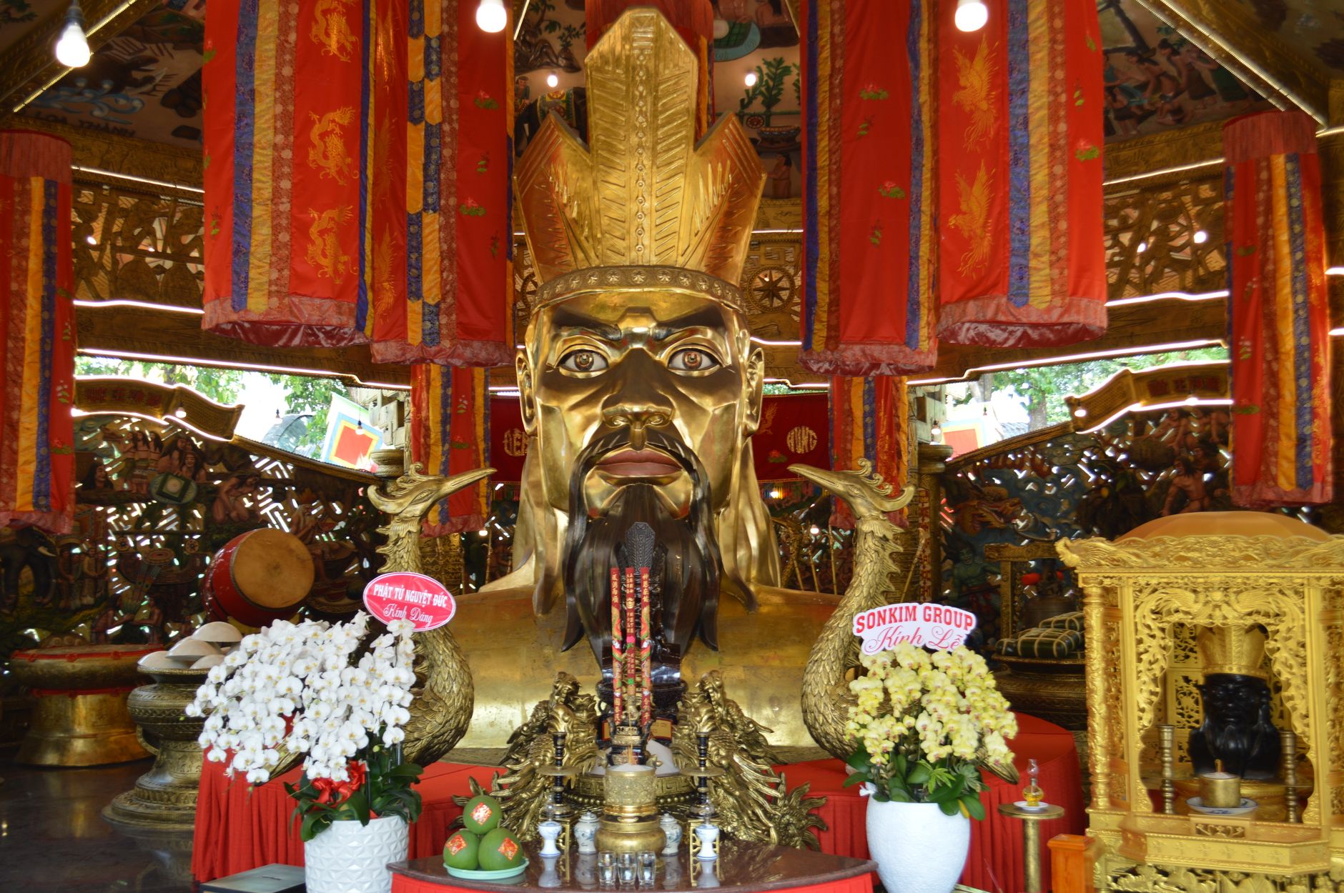 Intricate decorations with a grand golden statue inside an Asian temple, symbolizing cultural significance and spiritual