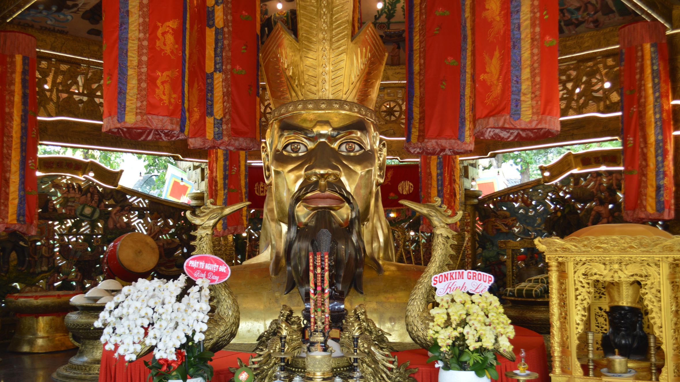 Intricate decorations with a grand golden statue inside an Asian temple, symbolizing cultural significance and spirituality.