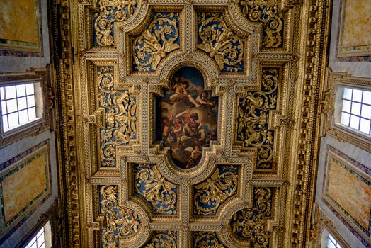 Intricate gold and blue ceiling adorned with Renaissance art in a Roman building.