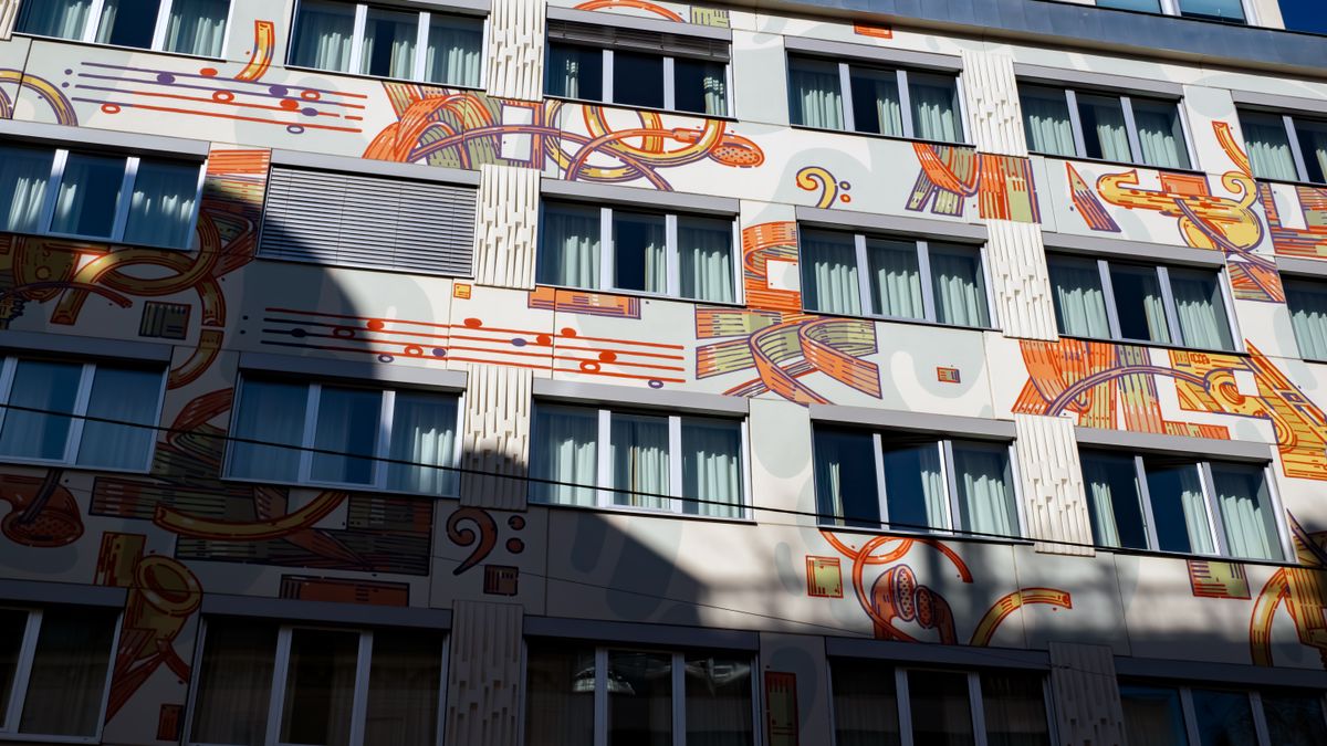 Large-scale mural covering a building facade with windows in Vienna — photo by Eleonora Vokueva on Pexels