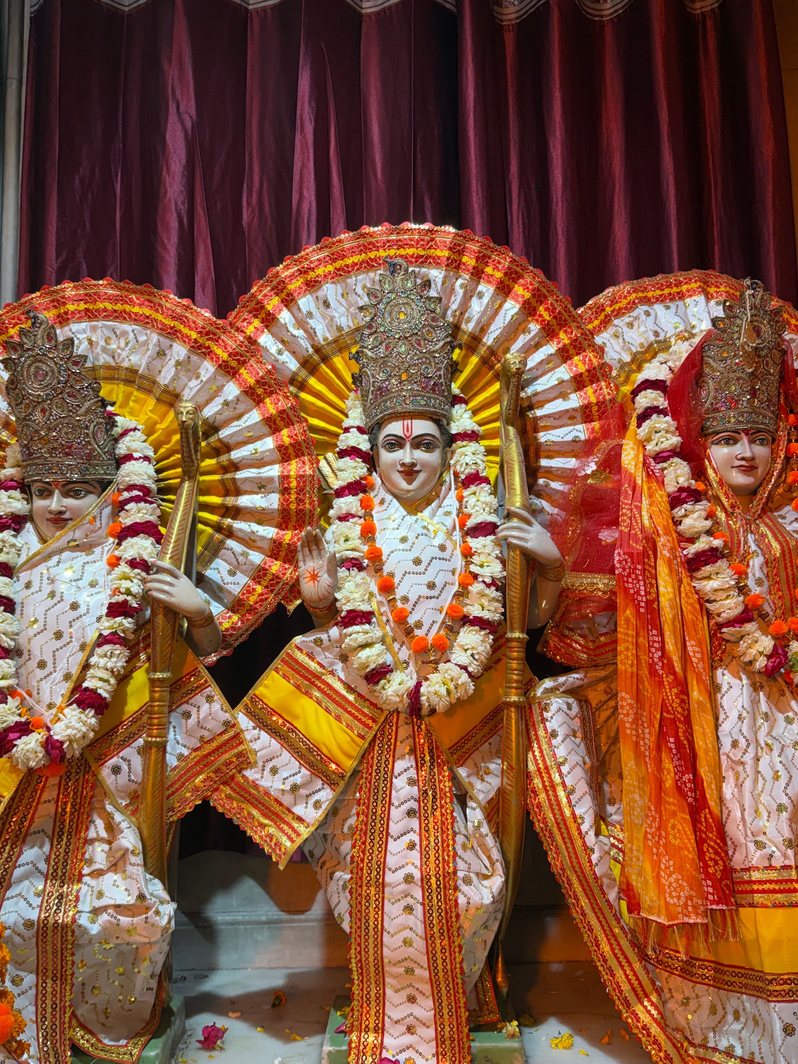 Colorful Hindu deities statues beautifully adorned with garlands and traditional attire, showcasing cultural heritage.